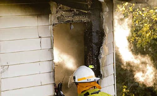 A firefighter looks into the bedroom where a 15-year-old girl was trapped and incinerated during an horrific house fire in West Street. A firefighter looks into the bedroom where a 15-year-old girl was trapped and incinerated during an horrific house fire in West Street.